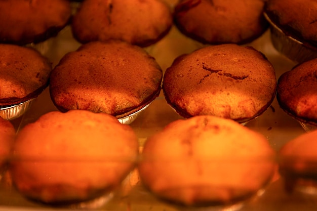 Een heleboel roze geportioneerde cupcakes op de toonbank in een winkel Traditionele gebakjes en dessert Close-up