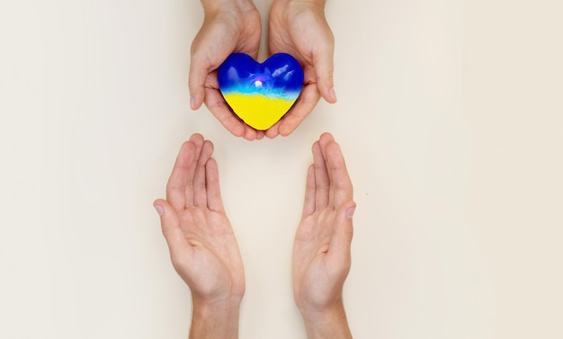 Een helpende hand helpt Oekraïne een hart in Oekraïense kleuren