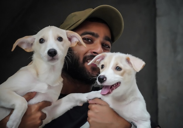 Een hondenliefhebber jonge jongen met 2 honden blij en lachend - selectieve focus afbeelding