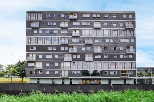 Een hoog gebouw met veel ramen en een blauwe lucht