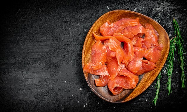 Een houten bord met plakjes gezouten zalm