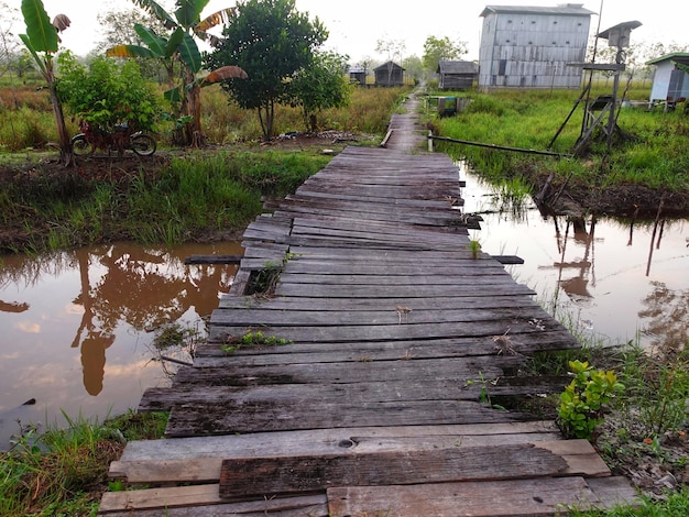 Een houten brug over een plas water.