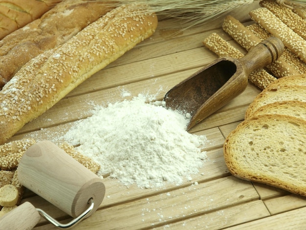 Een houten deegroller met brood erop en een houten handvat waar 'brood' op staat