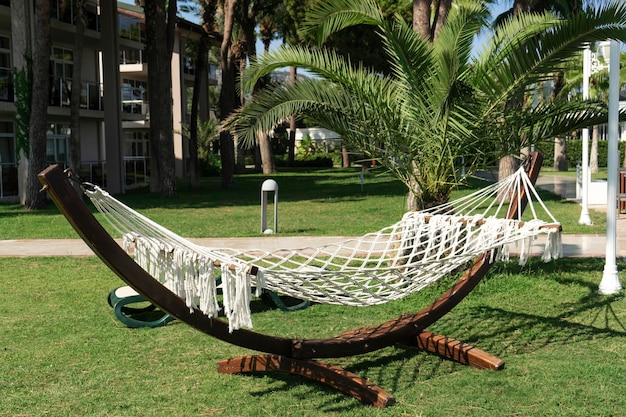 Een houten hangmat midden in de tuin