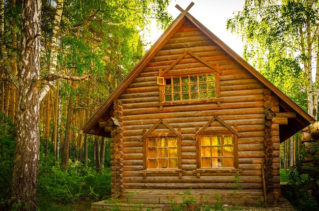 Een houten huis in het bos met een raam waarop 'het woord huis' staat