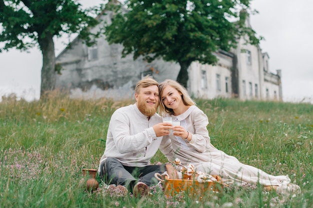 Een houten kist met brood en melk, een man en een vrouw samen in de natuur. Het concept van een gelukkig gezin en natuurlijke materialen.