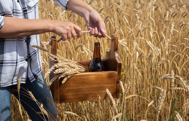 Een houten kistje met tarweoren en een glazen bierfles