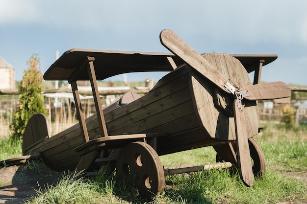 Foto een houten model van een vliegtuig dat in de zomer op straat staat