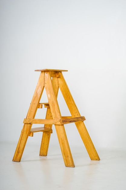 Een houten opstapkrukje met een ladder erop.