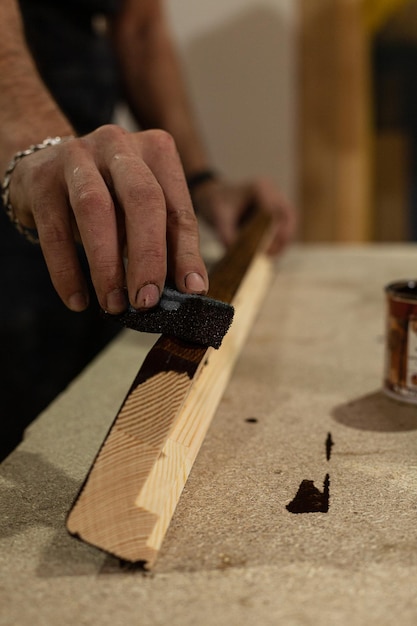 Foto een houten plank bruin verven in een timmerwerkplaats