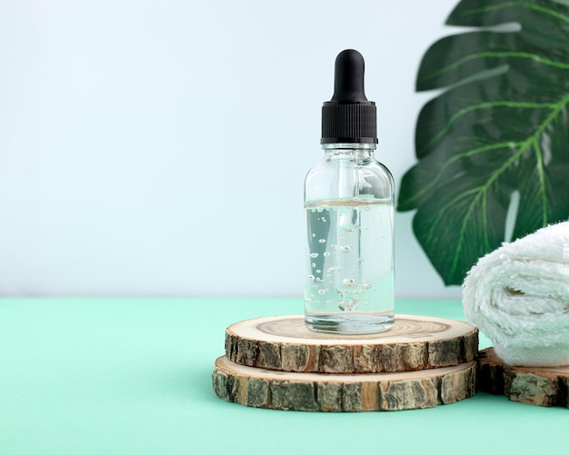 Een houten podium een wit servet een flesje met een pipet gevuld met olie of essence Lichaamsverzorging concept natuurlijke spa cosmetica