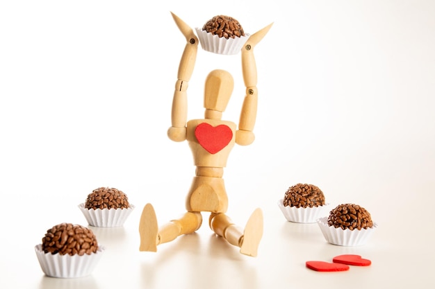 Een houten pop met een snoepje (brigadeiro)