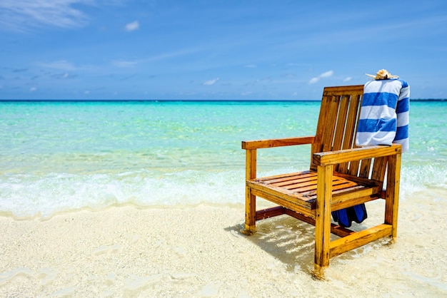 Een houten stoel in de Indische Oceaan met een handdoekschaal en flippers