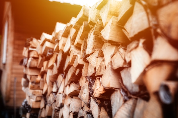 Een houtstapel met oogst- en gestapeld brandhout van gehakt hout voor het aansteken en verwarmen van het huis. brandhout van de berkenboom. gloed