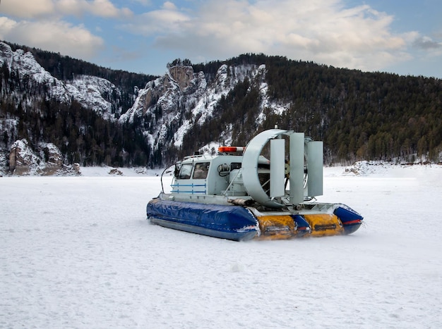 Een hovercraft glijdt over het oppervlak van een bevroren rivier Wintertoerisme