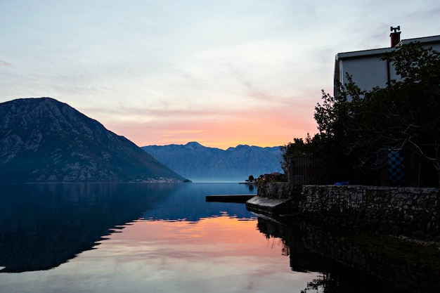 Een huis aan het meer met bergen op de achtergrond