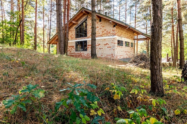 Een huis in aanbouw in een dennenbos op een zonnige herfstdag