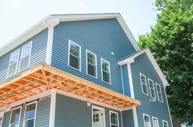 Een huis met een blauw huis met een houten dek met een blauwe zijwand die zegt "welkom in het huis".