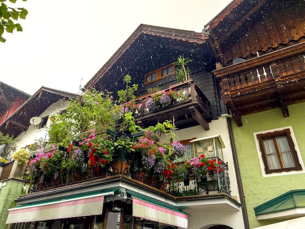 Een huis met veel bloemen op het balkon