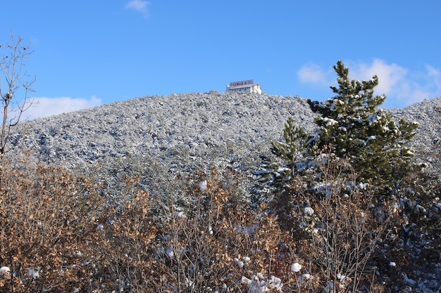 Een huis op een heuvel met sneeuw op de grond