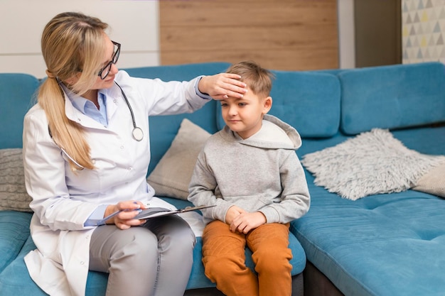 Een huisarts onderzoekt een kleine jongen thuis Kinderarts meisje behandelt een kind