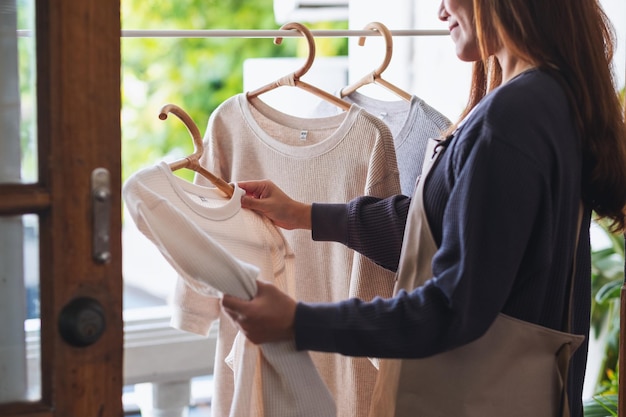 Een huisvrouw die de was doet en shirts thuis aan de waslijn hangt