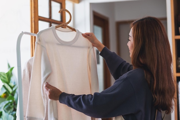 Een huisvrouw die was doet en hemden op de waslijn hangt.