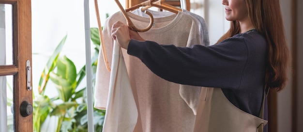 Een huisvrouw die was doet en hemden op de waslijn hangt.