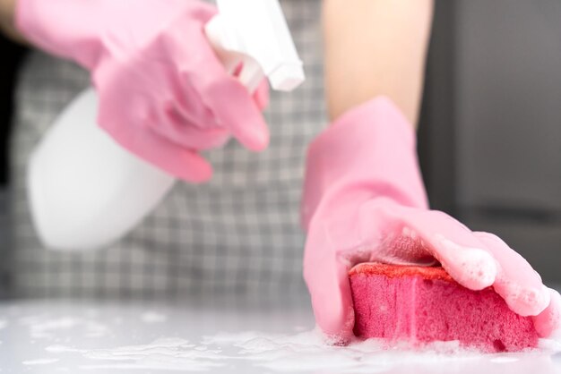 Een huisvrouw spat reinigingsmiddel op haar spons Huisreinigingsconcept Closeup Selectieve focus