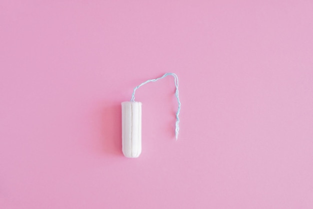 Een hygiënische tampon op een roze achtergrond Bescherming van de menstruatiecyclus
