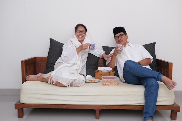 Een Indonesisch stel geniet thuis van een hapje en een drankje tijdens het vasten
