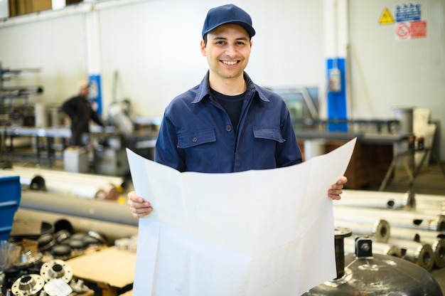 Een ingenieur kijkt naar een blauwdruk in een faciliteit