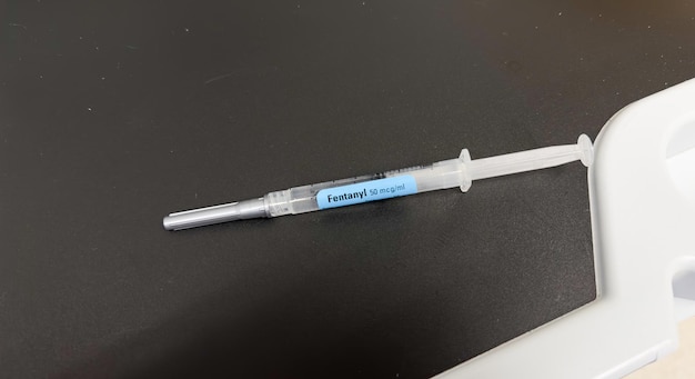 Een injectiespuit met een blauw label waarop "fertiliz" staat.