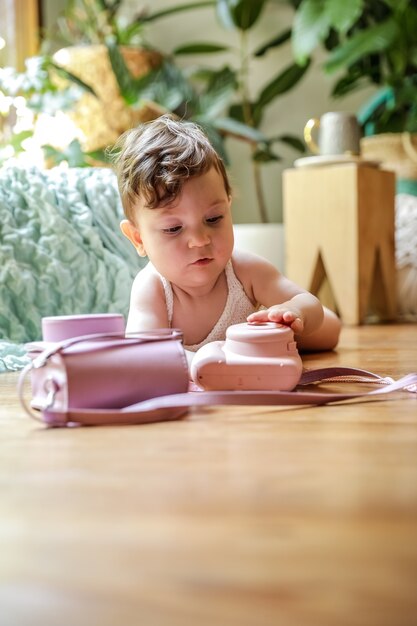 Een jaar oude baby spelen op de vloer met een vintage camera