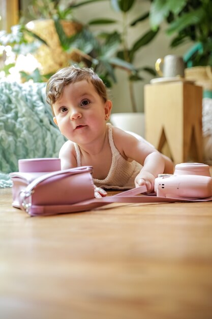 Een jaar oude baby spelen op de vloer met een vintage camera