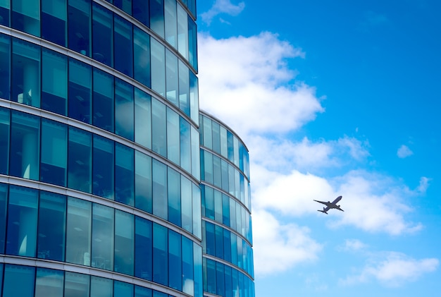 Een jetsilhouet met de achtergrond van bedrijfsbureautorens, londen