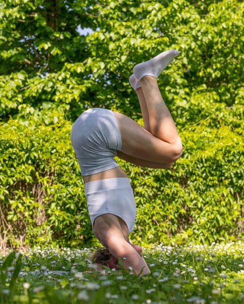 een jong atletisch meisje houdt zich bezig met yogasporten in de frisse lucht Schoonheid en gezondheid