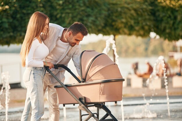 Foto een jong echtpaar met een kinderwagen loopt samen.