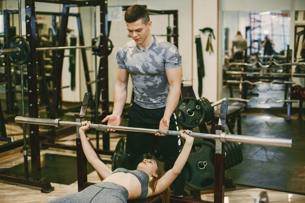 Een jong en atletisch paar oefent in een sportschool in sportkleding