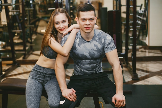 Een jong en atletisch paar oefent in een sportschool in sportkleding