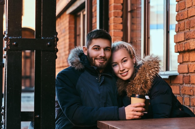 Een jong gelukkig stel brengt samen tijd door, koffie drinkend op het terras.