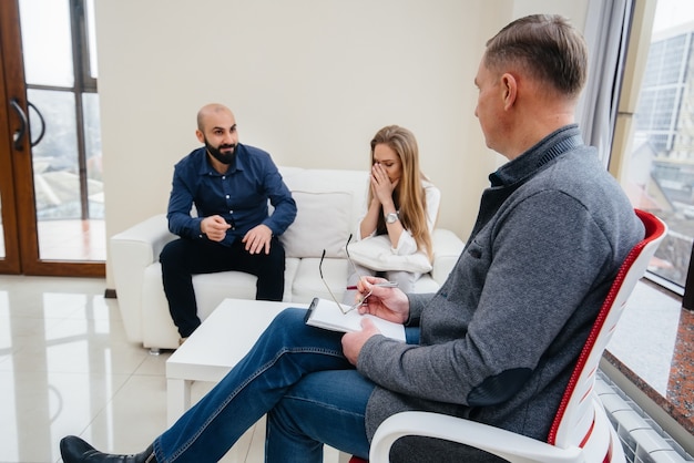 Een jong getrouwd stel van mannen en vrouwen praat tijdens een therapiesessie met een psycholoog. Psychologie.