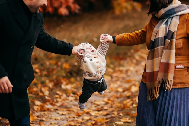 Een jong gezin loopt met hun zoon in een herfstpark