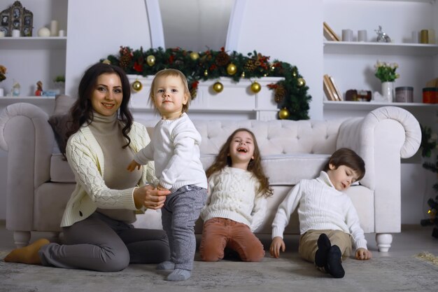 Een jong gezin met kinderen versiert het huis voor de vakantie. Oudjaarsavond. Wachten op het nieuwe jaar.