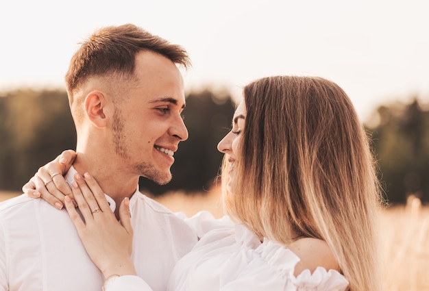 Een jong koppel man en vrouw knuffelen met tederheid in de natuur in de zomer. Geliefden