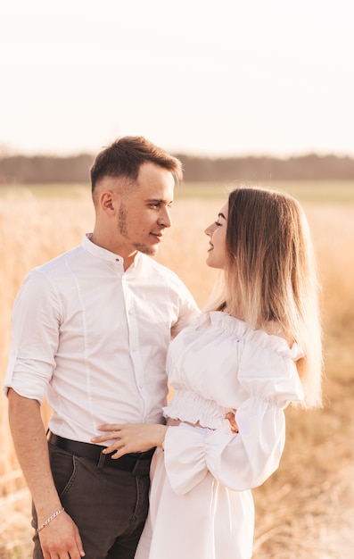 Een jong koppel man en vrouw knuffelen met tederheid in de natuur in de zomer. Geliefden