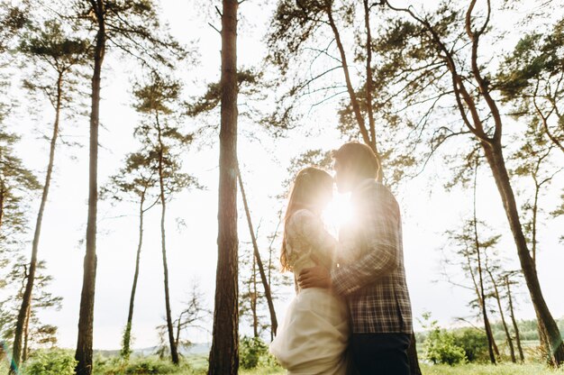 Een jong koppel van bruiden wandelen in het dennenbos