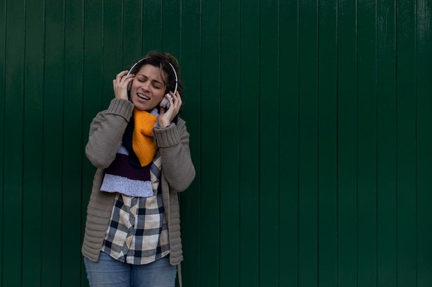 Een jong Latijns-Amerikaans meisje luistert naar muziek met haar koptelefoon, lacht, zingt en heeft plezier