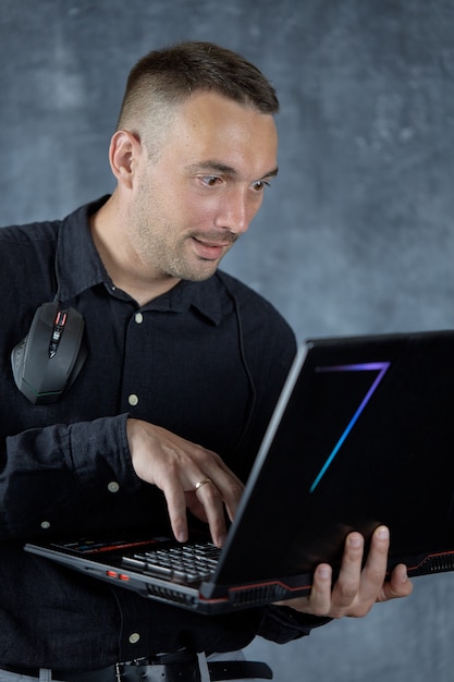 Een jong mannelijk model poseert met een laptop in zijn handen