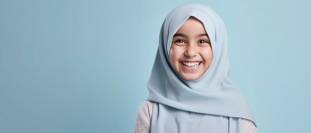 een jong meisje dat een hijab draagt, glimlacht naar de camera